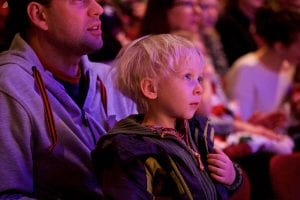 Photo from the event of a small child, captivated by the events on stage.