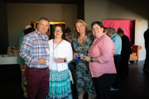 Photo of Gala attendees, 4 in total, standing side by side in the new rehearsal hall, smiling for the camera.