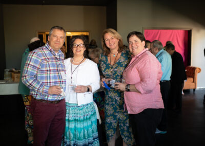 Photo of Gala attendees, 4 in total, standing side by side in the new rehearsal hall, smiling for the camera.