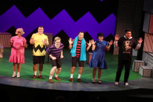 Photo of the complete cast of "You're a Good Man, Charlie Brown" singing together.