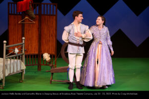 Prince Albert (Jackson Wells-Benitez) and Princess Penelope (Samantha Blaine) stand arm-in-arm, smiling at each other proudly having broken the curse.