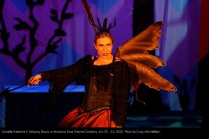 Harriet the Witch (Danielle Valentine) sings in bold amber mood lighting.