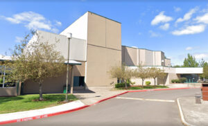 Photo of the exterior of the Deb Fennell Auditorium: a large white building several stories tall to accommodate the curtain, light, and fly-system of the stage itself.