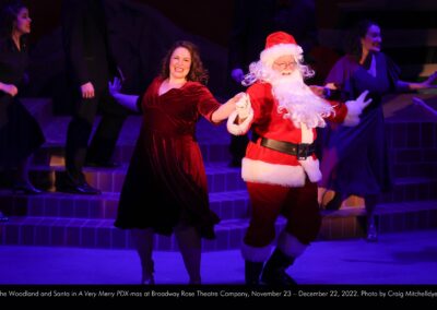 Blythe Woodland and Santa in A Very Merry PDX-mas at Broadway Rose Theatre Company, November 23 - December 22, 2022. Photo by Craig Mitchelldyer.