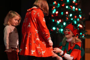 Santa's helpers complimenting the kids on their wonderful Christmas dresses.
