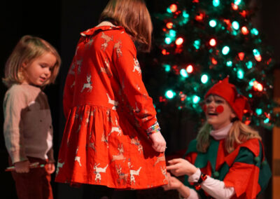 Santa's helpers complimenting the kids on their wonderful Christmas dresses.