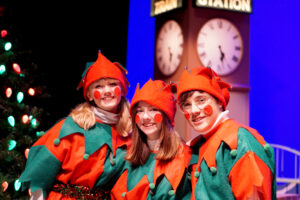 Santa's helpers on stage for a group picture.