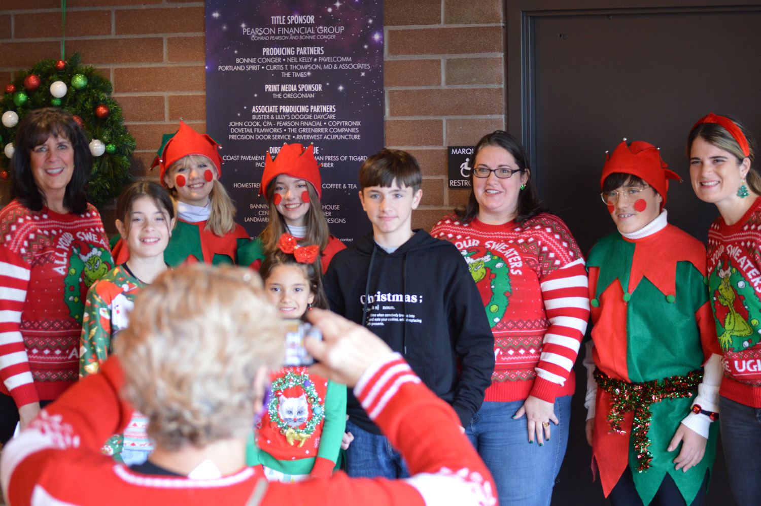 A family posing with Santa's helpers in the lobby.