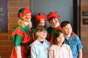 Santa's helpers posing with a family in the lobby.