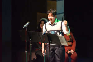 Broadway Rose cast members dressed in festive clothes sing songs for the crowd of kids and families.
