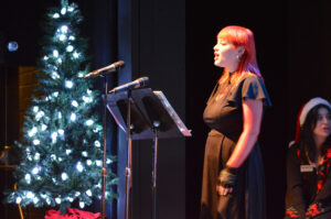 Broadway Rose cast members dressed in festive clothes sing songs for the crowd of kids and families.