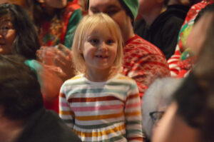 A child in the crowd looks on with wonder.