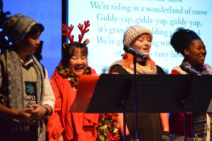 Cast members singing another Christmas carol.