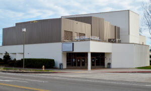 Photo of the exterior of the Deb Fennell Auditorium: a large white building several stories tall to accommodate the curtain, light, and fly-system of the stage itself.