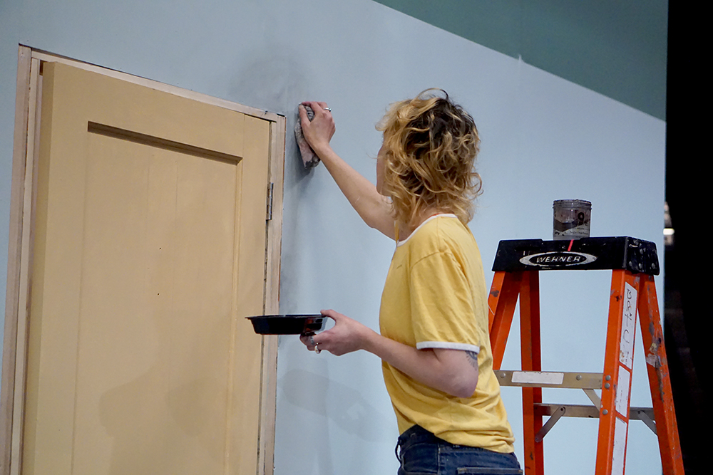 Elaine aging the walls on the Audition From Hell set