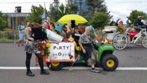 Photo of Judy and friends in the Pooper Scooper mobile in a local parade.