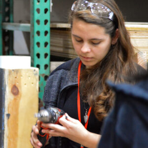Photo of a summer intern using a power drill.