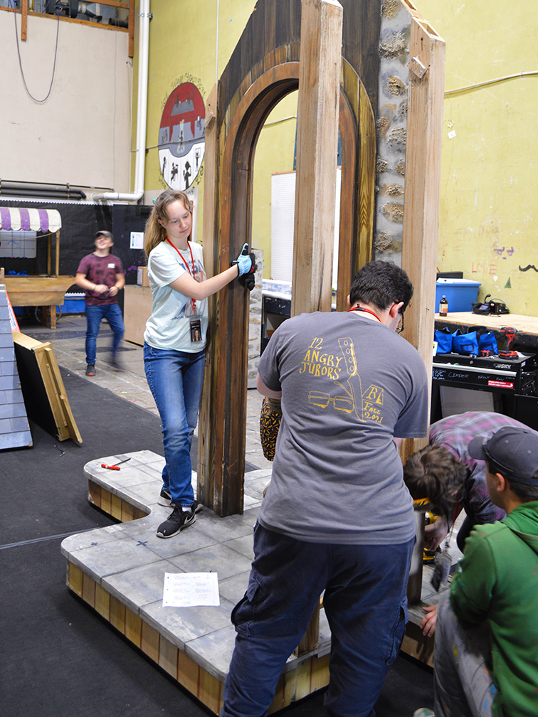 Set construction Photo of interns back stage constructing a faux stone doorway for the 2023 production of Cinderella.