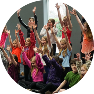 Photo of a group of kids performing in the rehearsal hall.
