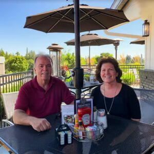 Photo of Mark and Trish Banning on the patio of Banning's Restaurant on a bright summer day