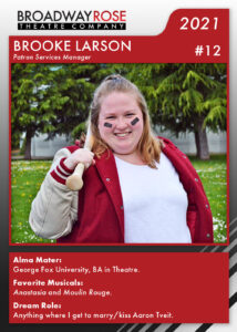 A sports card with a photo of Brooke Larson. She's wearing a red and white letterman jacket with a baseball bat slung over her shoulder, smiling for the camera. The text reads: Alma Mater: George Fox University, BA in Theatre. Favorite Musicals:Anastasia and Moulin Rouge. Dream Role: Anything where I get to marry/kiss Aaron Tveit.
