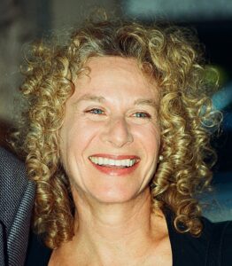 Photo of Carole King in 2002. She is smiling for the crowd of fans gathered to see her.