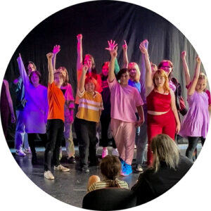 Photo of Teens from our 2022 Teen Cabaret. They are all posing at the end of a song with their fists held high in the air.