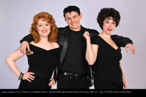 Photo of Sophie MacKay, Victor Polanco, and Melissa Gale in a studio photo session with a gray background. They are in all black outfits like the ones at the end of the show and film version.