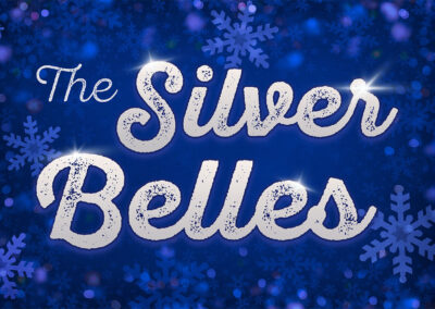 Logo for The Silver Belles. The text is in a glittering silver font over a bold blue background filled with light blue snowflakes.