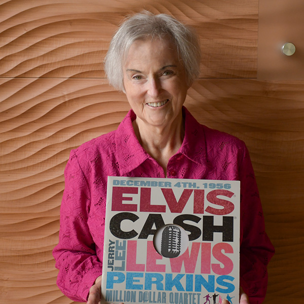 Photo of Brian Moen in front of the carved wood wall in the Broadway Rose lobby.