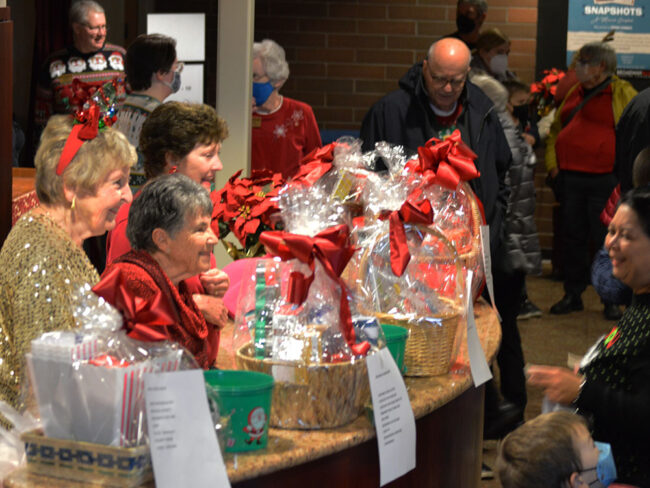 Photo of members of the guild at a Santa Sing-Along. This group is in the lobby talking to the crowds as they enter the theater.