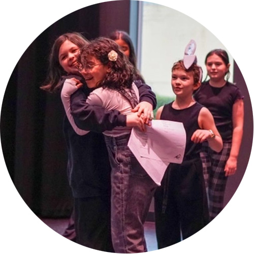 Photo of two young girls hugging during a Kids Showcase performance here at Broadway Rose.