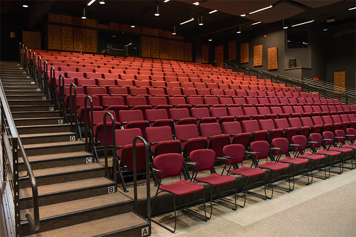 Photo of the seating at the New Stage, showing the widened stair cases, hand rails, and wheelchair accessible front row.