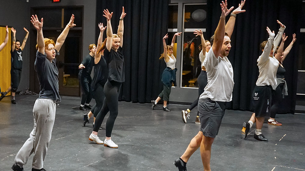 Dance Workshop A photo from one of our dance workshops showing a group of people striking a pose with arms wide above their heads.